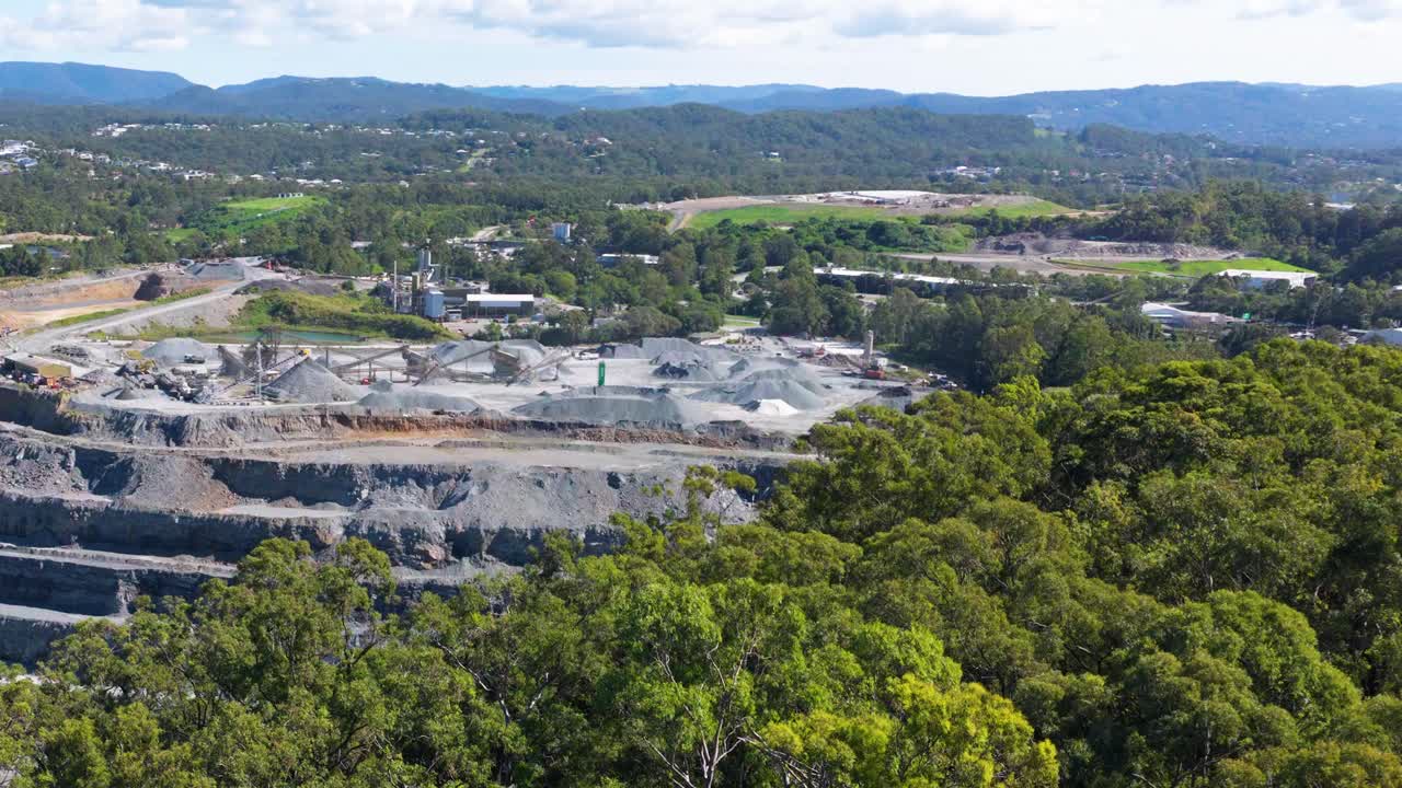 Drone footage captures expansive views of Mount Coot-tha Quarry, showcasing terraced rock formations and surrounding greenery under clear skies