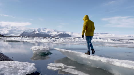 Junger-Blonder-Männlicher-Reisender,-Der-Auf-Eiskanal-In-Der-Gletscherlagune-In-Island-Geht