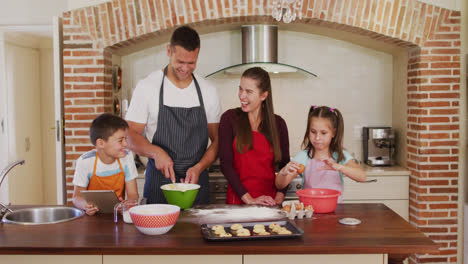 familia caucásica con delantales cocinando juntos en la cocina en casa