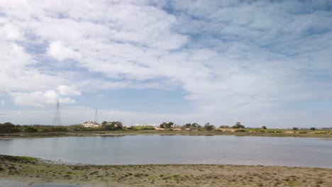 slow driveby of marsh lagoon in cadiz, spain on cloudy day