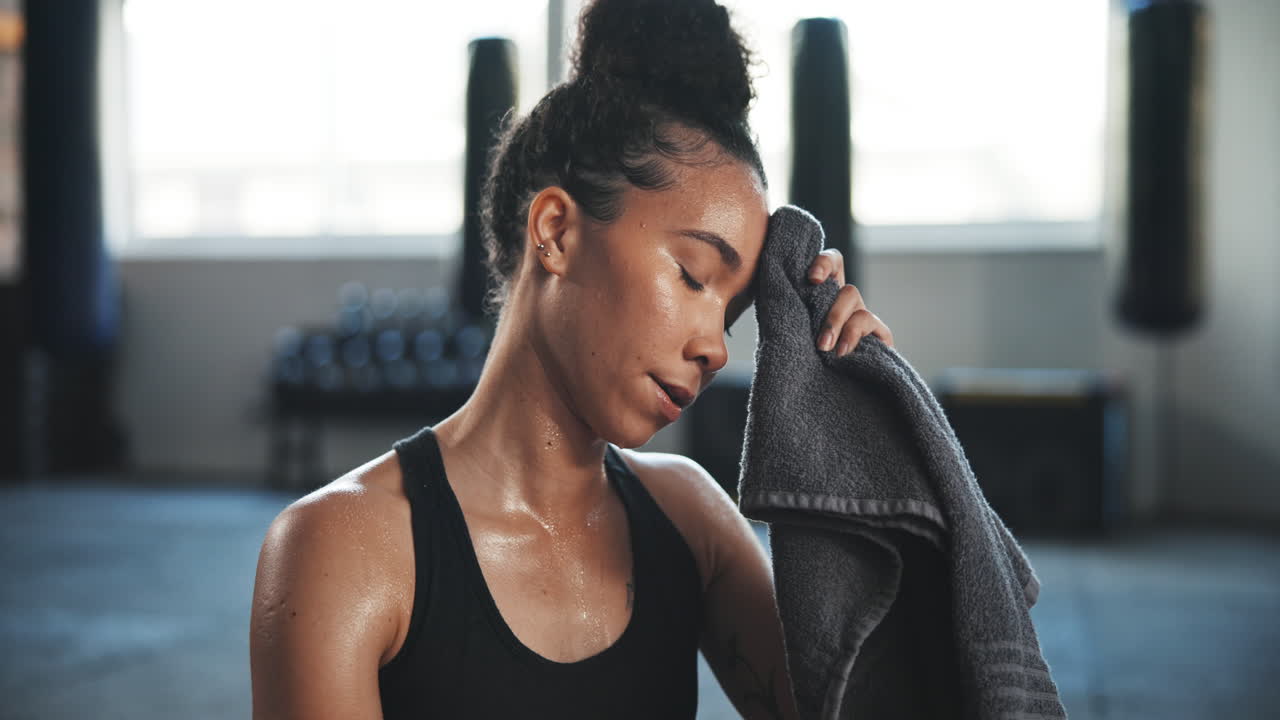 Tired, sweating and towel with woman in gym