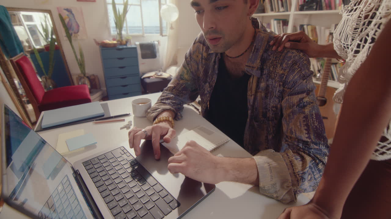 Young Couple Using Laptop and Speaking in Sunlit Room