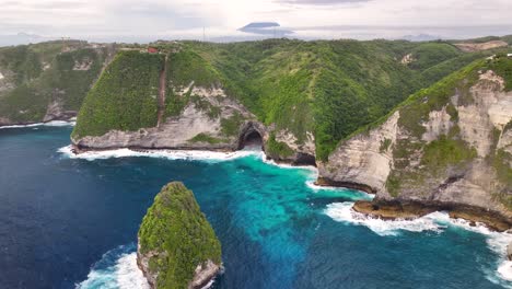 drone flying to hidden cave in steep limestone cliff, nusa penida, bali. beauty in nature.