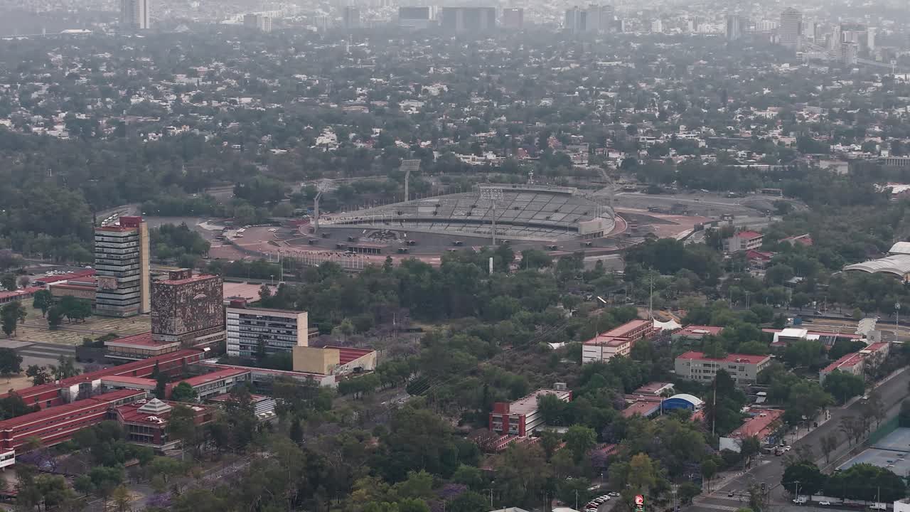 Main buildings of university campus, with Olympic Stadium in background, seen from a drone