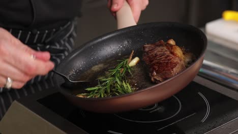 chef cocinando un filete con romero y ajo