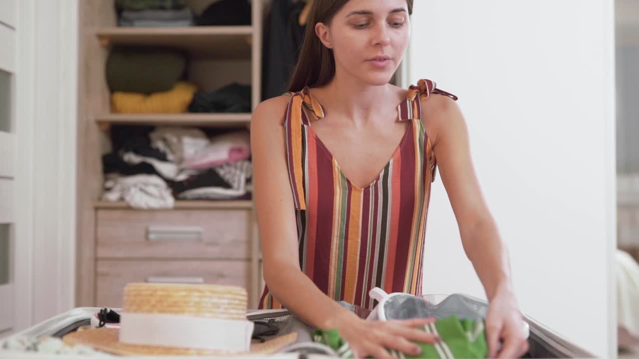 hermosa chica recoge una maleta para vacaciones y comprueba si todo está tomado