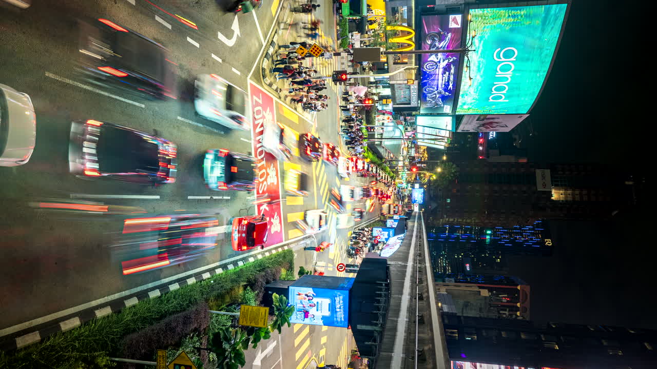 Vertical nightlapse of busy Bukit Bintang crossing with traffic and people