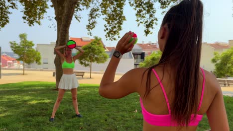 women playing paddle ball in park
