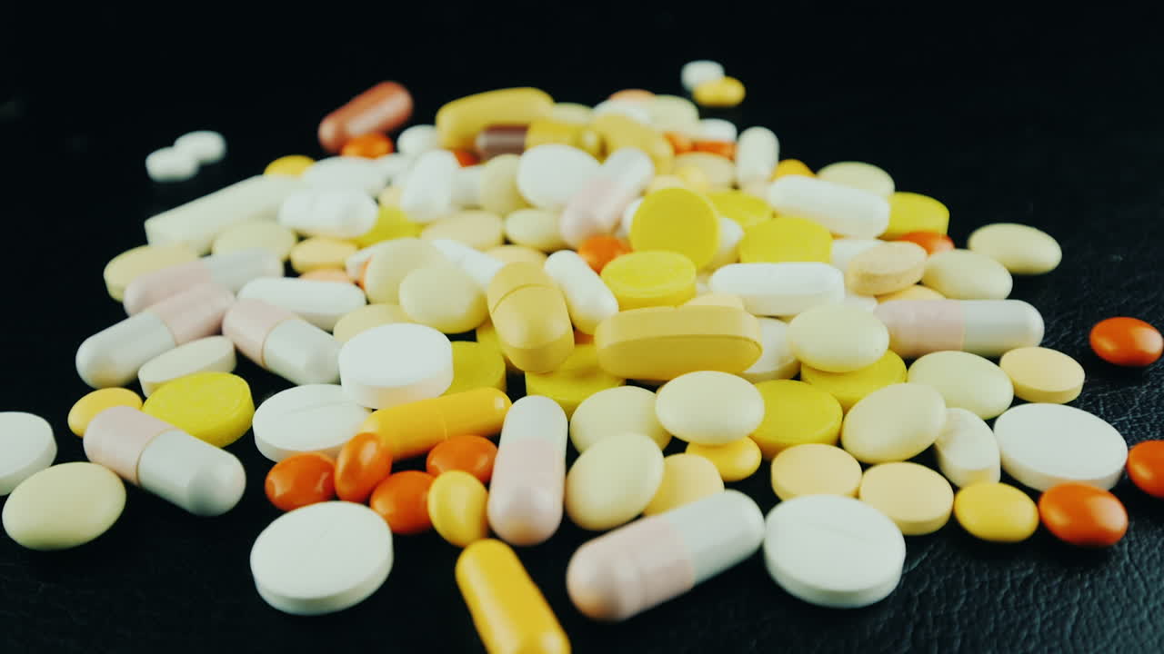las manos mueven un montón de pastillas y cápsulas