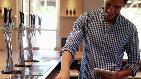 bar tender using digital tablet at counter 4k