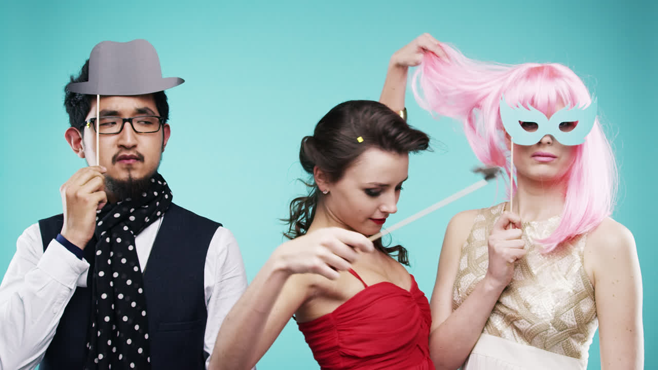 세 명의 매력적인 친구들이 파티 슬로우 모션 사진 부스에서 춤추고 있습니다.