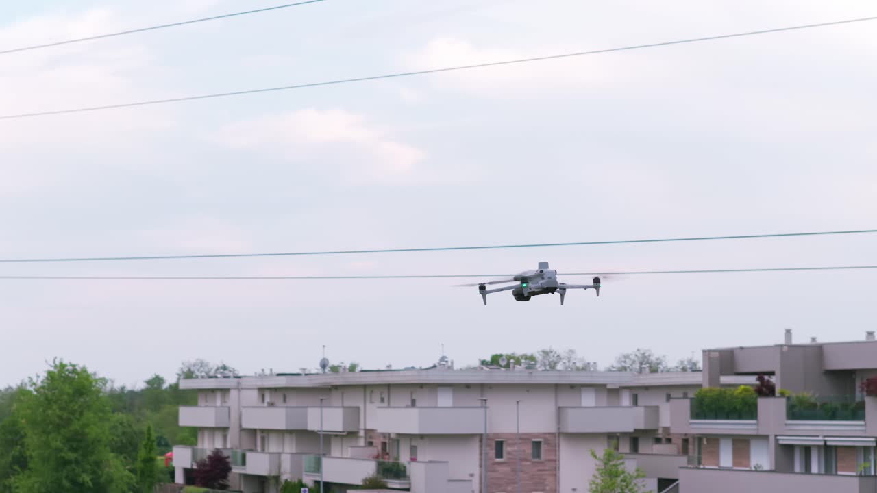 Drone flying with buildings in background, urbanscape, aerial surveillance or infrastructure inspection, UAV technology