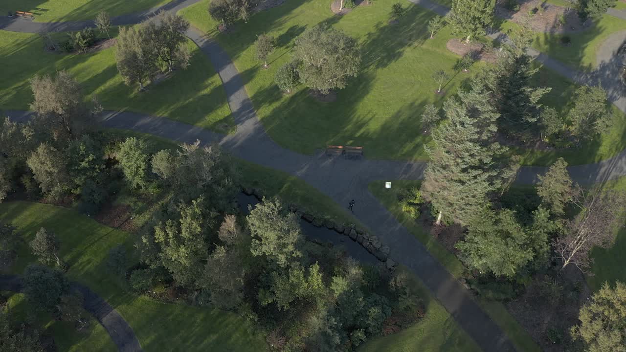 мужчина бежит трусцой по ботаническому саду рейкьявика на закате, аэрофотосъемка