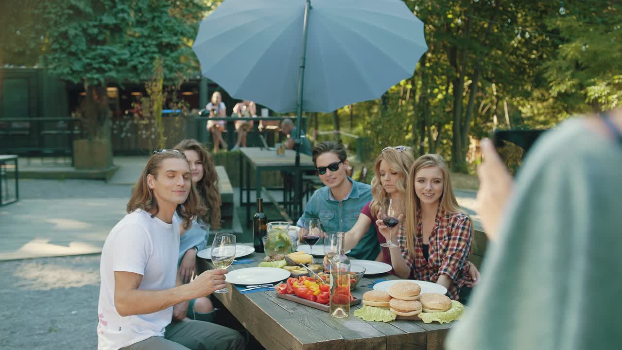와인을 마시며 드폰으로 사진을 찍는 친구들.