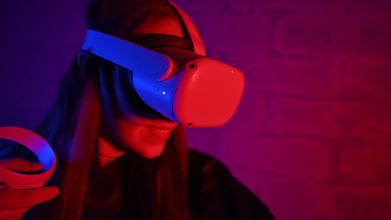 A young interested woman playing in VR games using VR glasses and controllers. Red and blue illumination. Slow motion