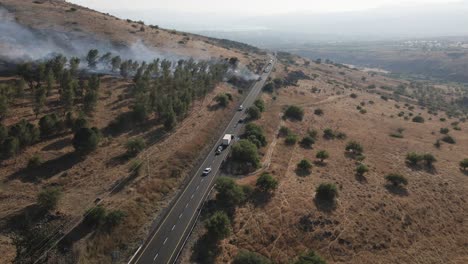 Drone-flyover-of-brush-fire-and-smoke-from-burning-passenger-bus-on-highway