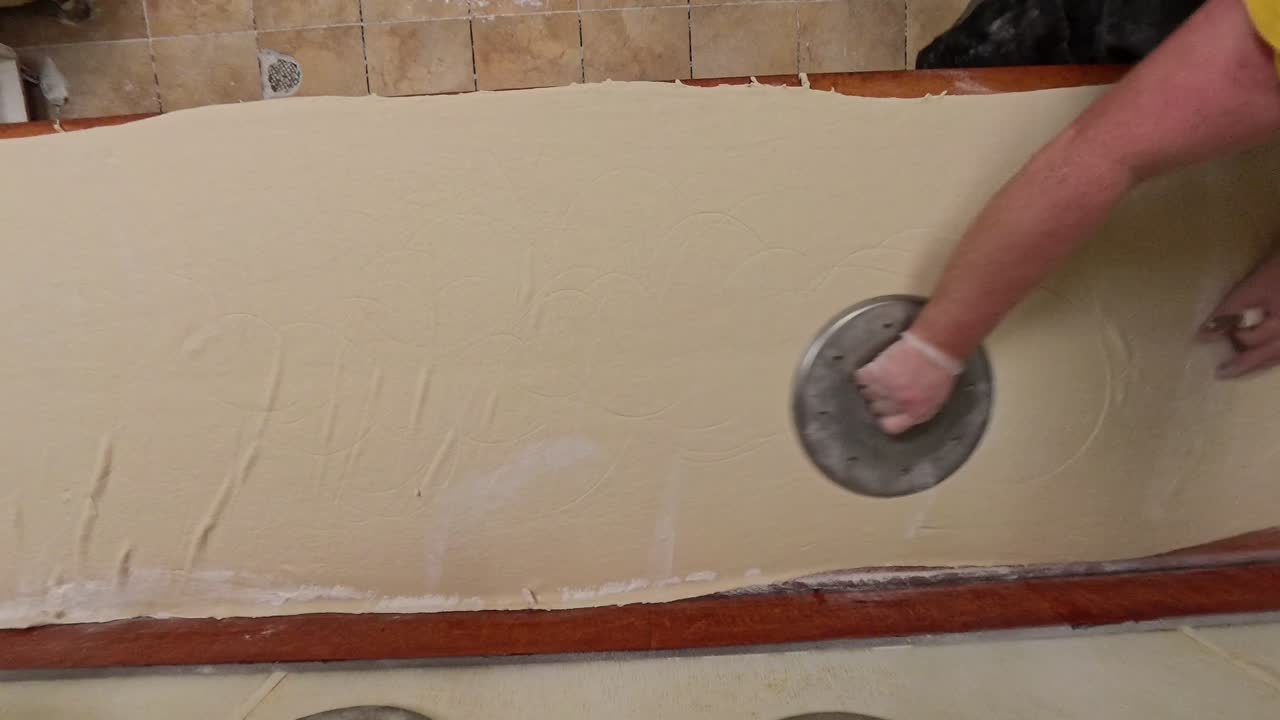 Top down dough being stretched on a table