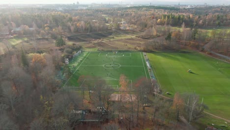 drone footage gliding inwards towards a soccer field, showcasing players in dynamic motion