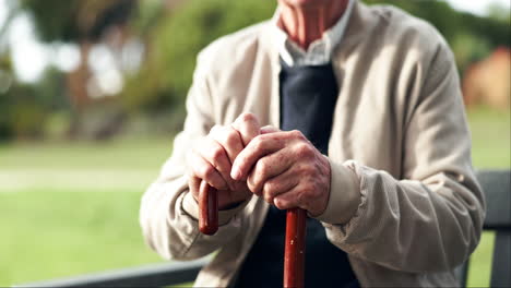 senior man resting with walking stick in park