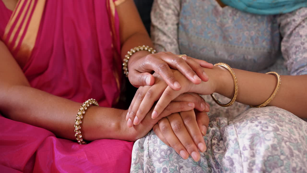 Tenendosi per mano, madre e figlia indiane che indossano il sari mostrano unità e supporto.