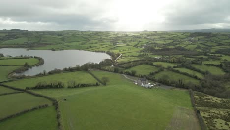 typical green-hued landscape with river over county cavan, ireland during sunrise