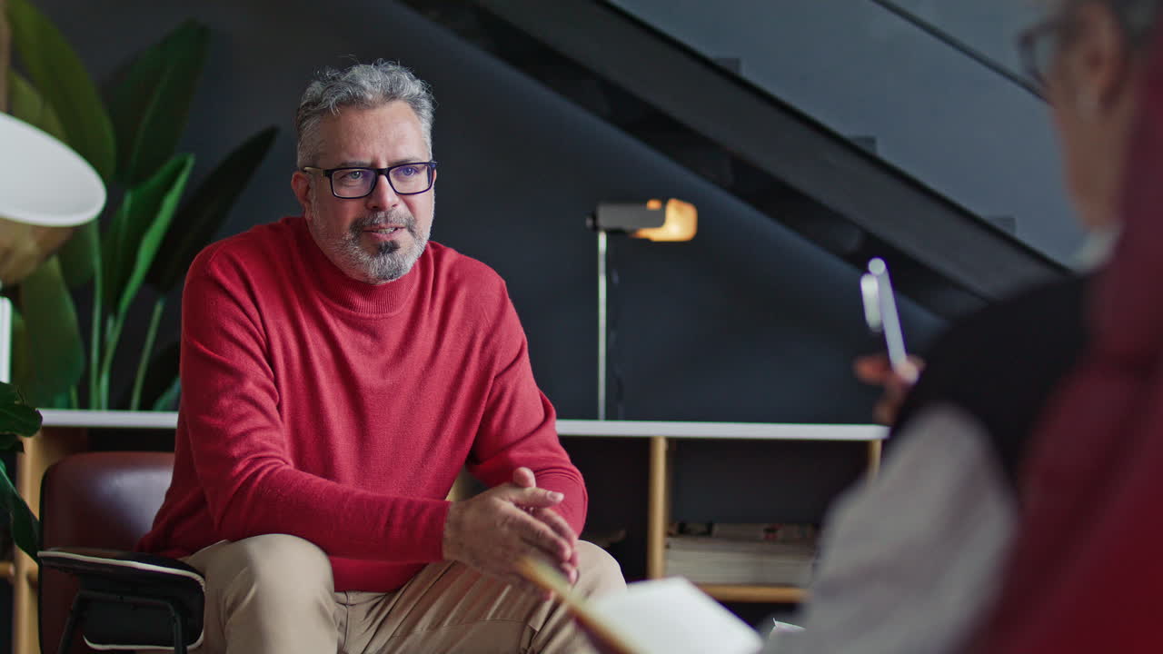 Mid-Aged Man Answering Questions from Psychologist during Counseling Session