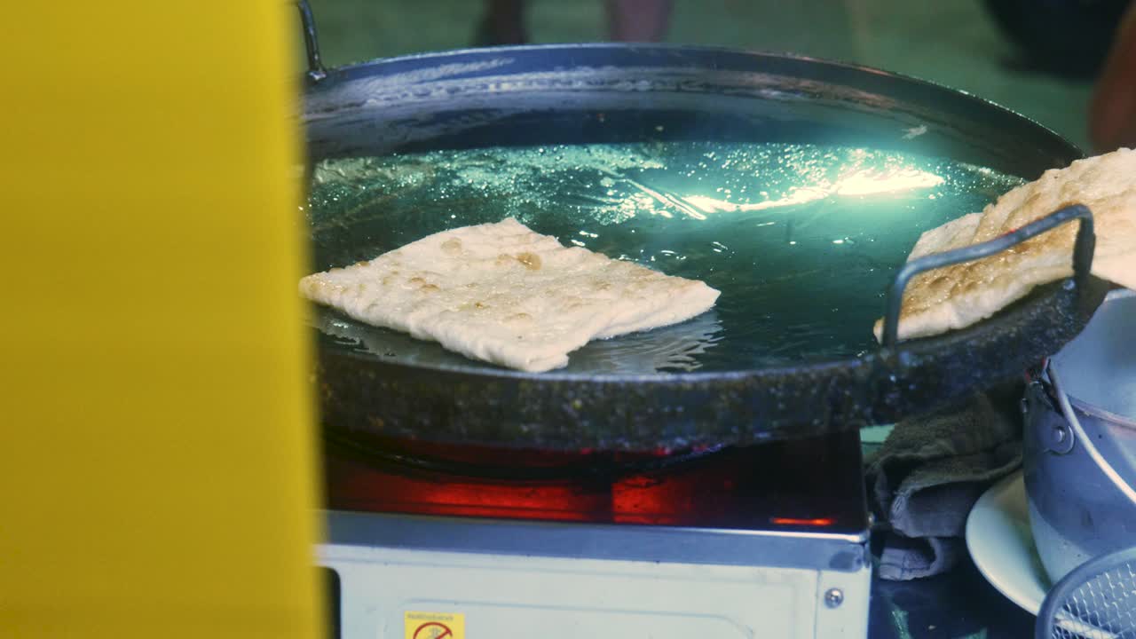imágenes cinematográficas de cocina de 4k de un chef tailandés preparando un postre tradicional tailandés llamado roti en un mercado callejero en tailandia