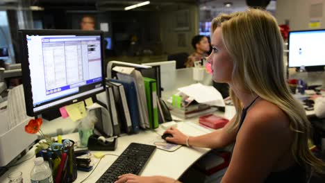 pretty blond woman working at desk on computer