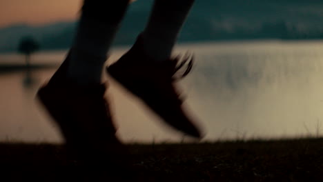 person running by a lake at sunset