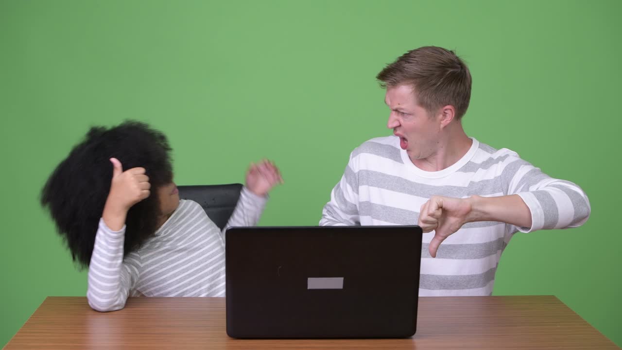 젊은 아프리카 소녀와 젊은 스칸디나비아 남자가 함께 노트북을 사용하고 있습니다.