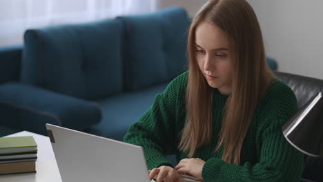 Die-Junge-Frau-Arbeitet-Von-Zu-Hause-Aus-Mit-Einem-Laptop-Im-Wohnzimmer,-Freiberuflich-Und-Unabhängig,-Spezialistin-Für-Computersoftware