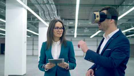 un hombre con gafas de realidad virtual y un agente de bienes raíces caminando por el pasillo.