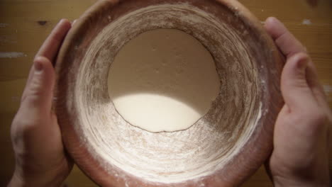 sourdough - nurturing, caring hands are placed on the bread mixing bowl