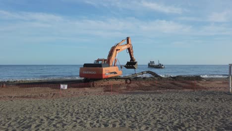 las excavadoras bombean arena a lo largo de la costa para proteger la playa erosionada