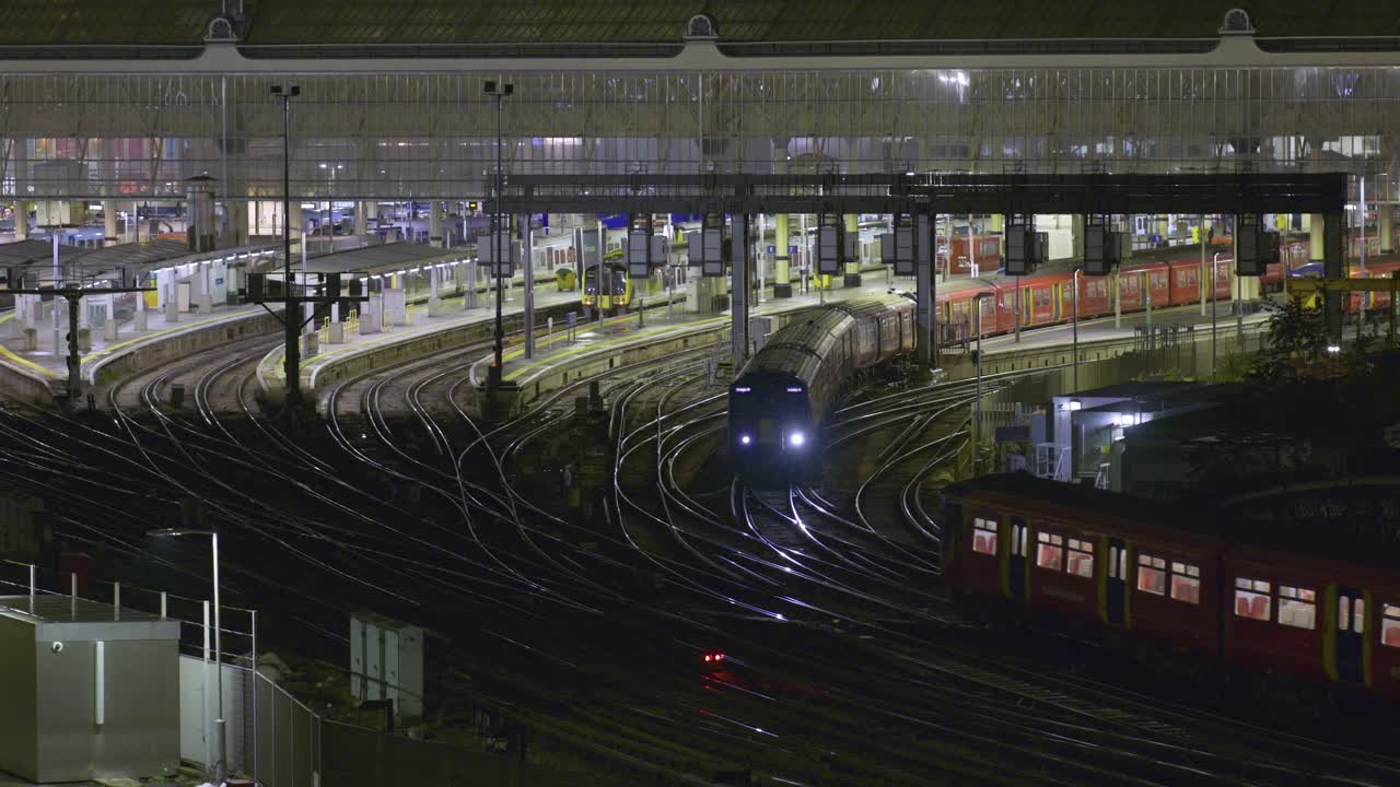 Multiple trains arriving and departing at the same time at London Waterloo station at night