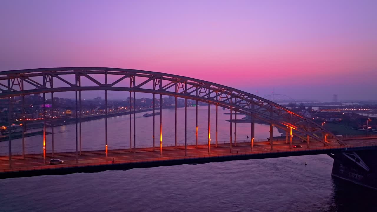Aerial view of Waal bridge shimmering with traffic lights after dark