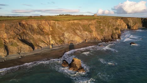 Costa-De-Waterford,-Hora-Dorada-Mientras-El-Sol-De-La-Tarde-Baña-Los-Acantilados-Con-Luz-Dorada