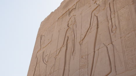 ancient egyptian carvings on a stone wall at dendera, showcasing detailed hieroglyphs