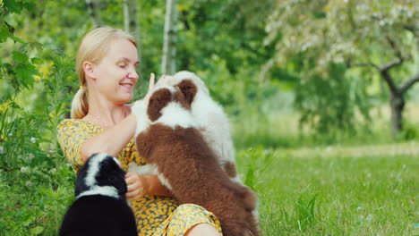 active young woman plays with several puppies in her backyard