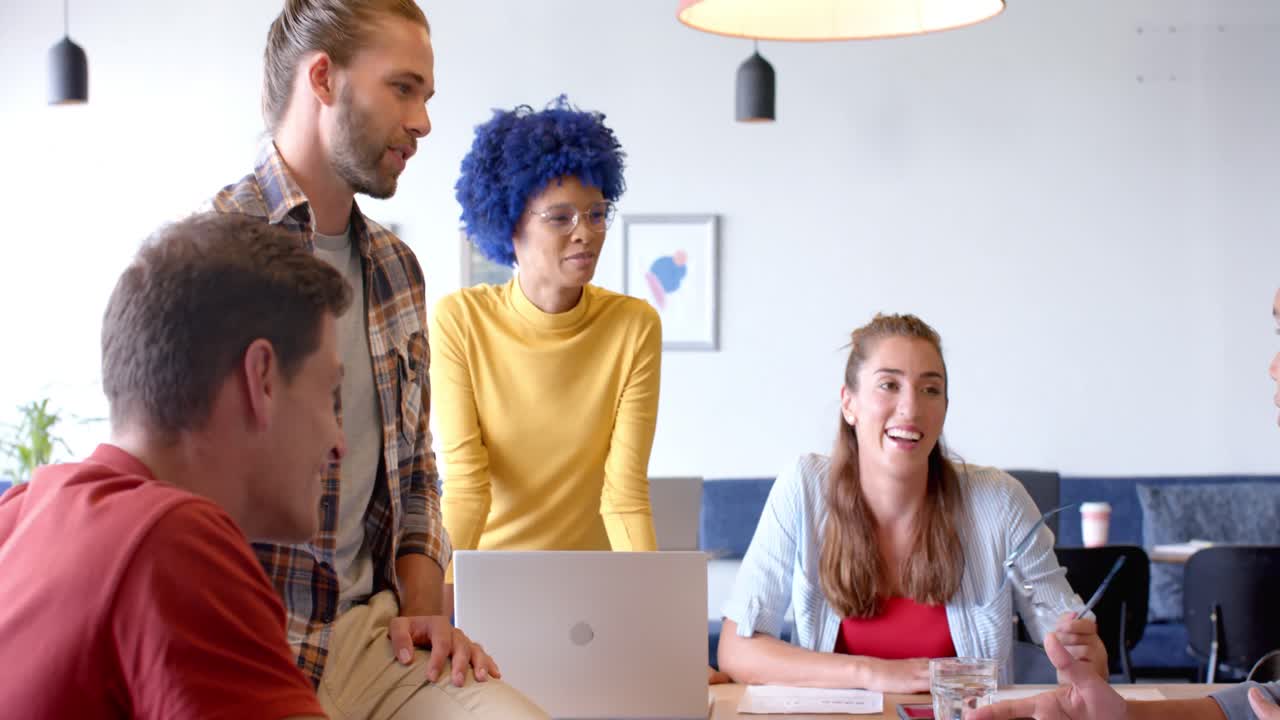 Happy diverse creative colleagues discussing in casual meeting at office, slow motion