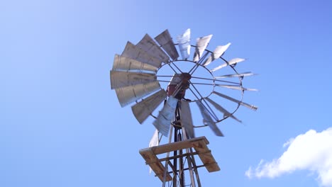 the windmill as its blades rotate, powered by the wind