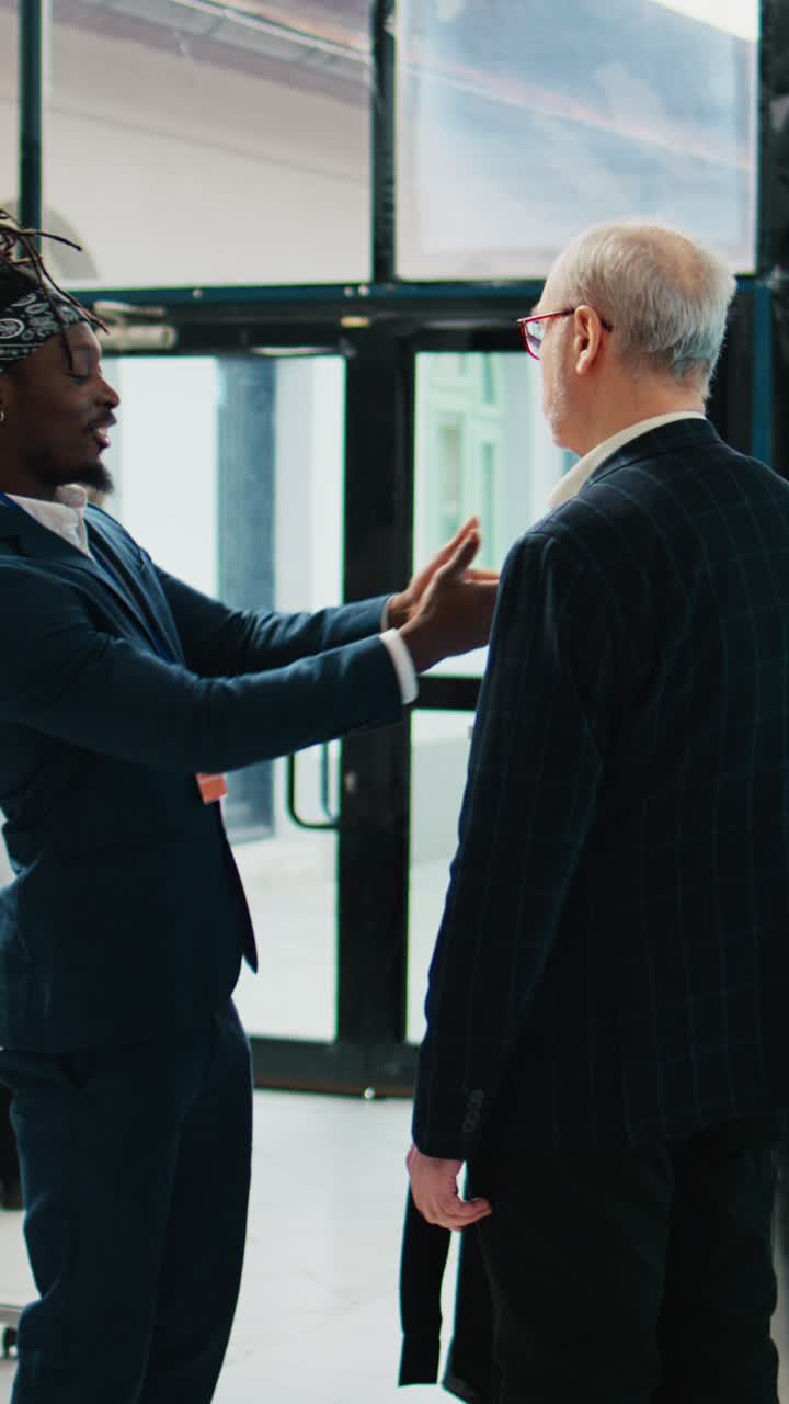 Vertical Video Retail clerk suggesting a tie to match a black shirt for formal wear