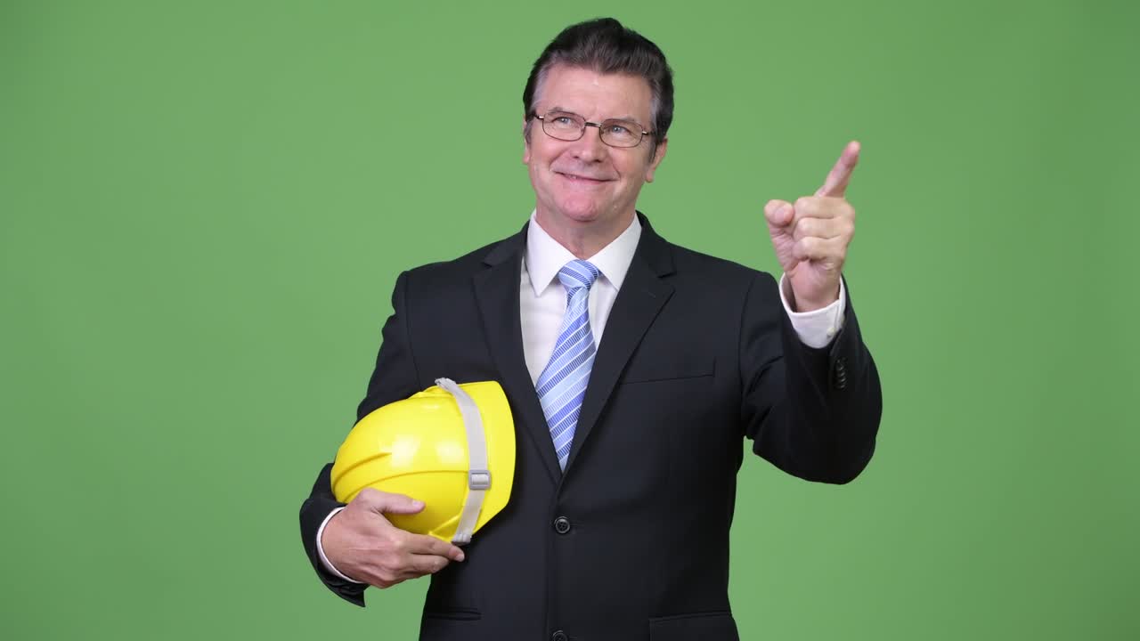 Senior handsome businessman as engineer pointing finger