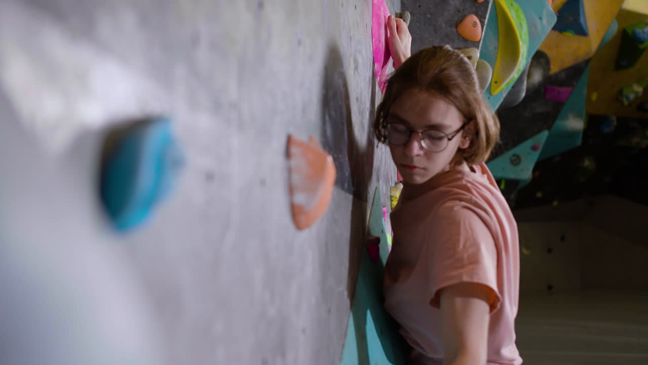 muchacho adolescente bouldering en el interior