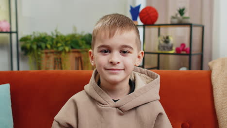 portrait of happy smiling caucasian preteen school boy child kid looking at camera home play room