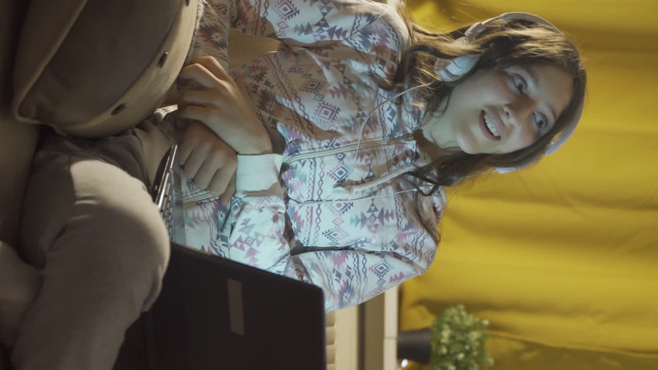 남자 학생의 수직 비디오가 집에서 밤의 행복한 추억을 기억하고 웃고 있습니다.