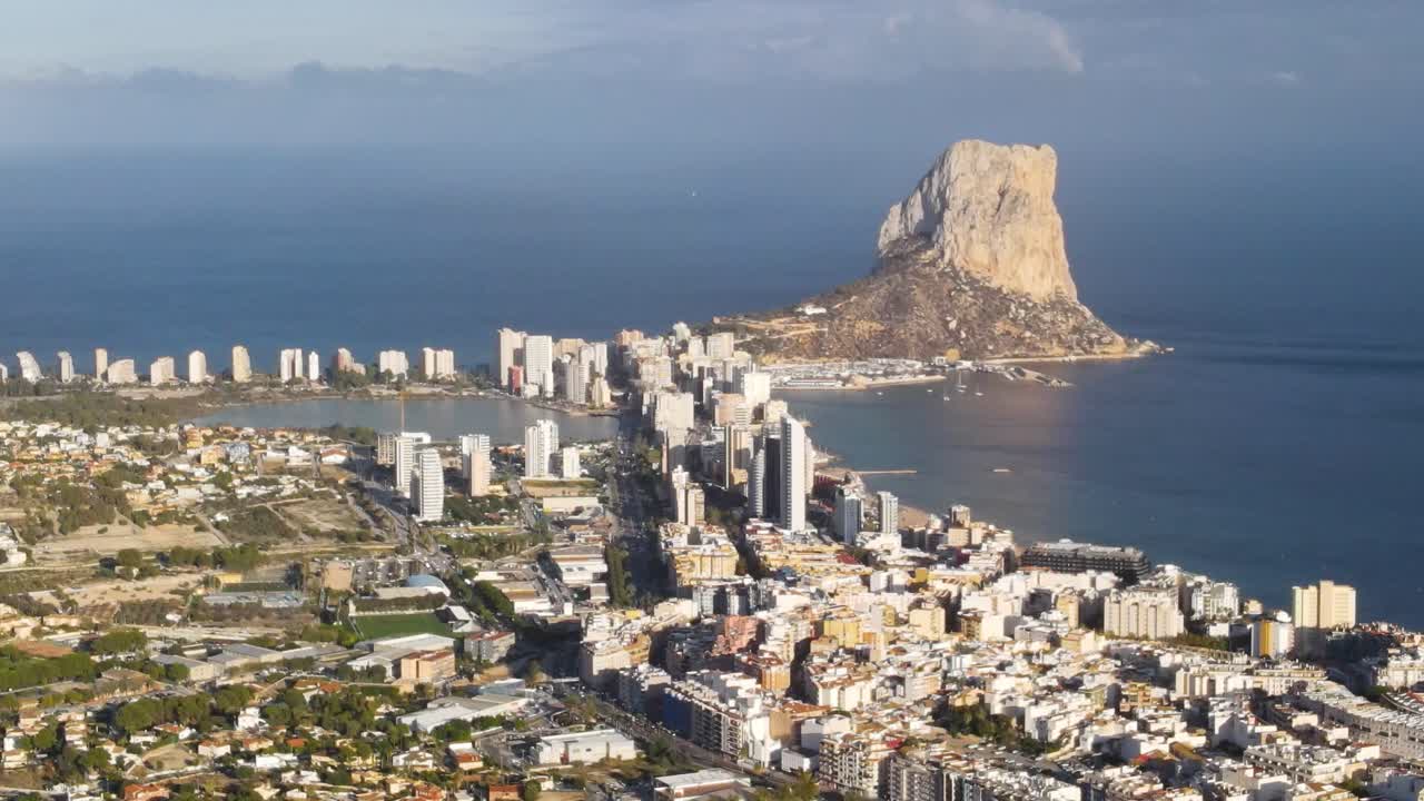 Calpe coastline and penyon d'ifach rock formation on a sunny day , aerial view