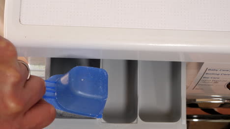 man pours detergent into the washing machine detergent powder draw