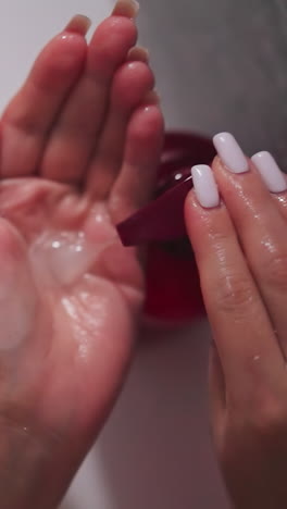 woman squeezes gel on palm in bathroom closeup. lady takes liquid soap from dispenser bottle in shower. woman uses natural cosmetic product