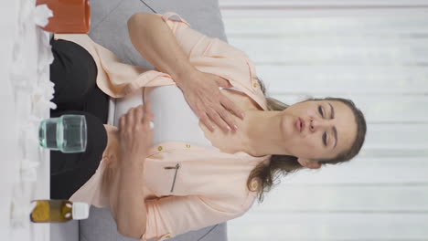 video vertical de una mujer con dolor en el pecho.
